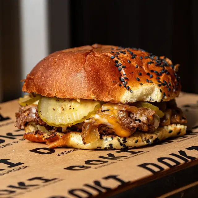 Smash burger z serem i ogórkiem na papierze DOKI