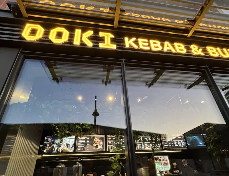 Czarna fasada z podświetlonym napisem DOKI Kebab & Burger